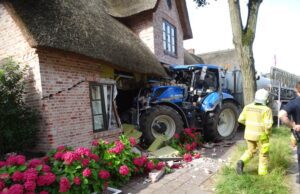 Traktor mit Anhänger landet im Gebäude – Medizinischer Notfall beim Fahrer?